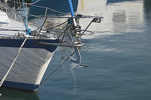 Anker in der Bugrolle einer Yacht mit Ankerkette und Bugbeschlägen