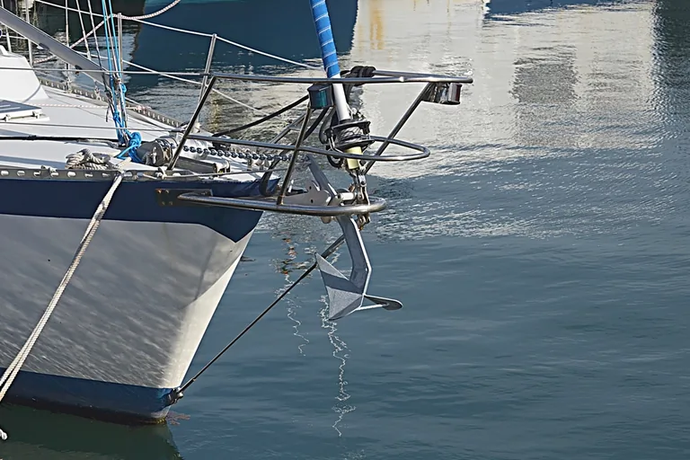Anker in der Bugrolle einer Yacht mit Ankerkette und Bugbeschlägen