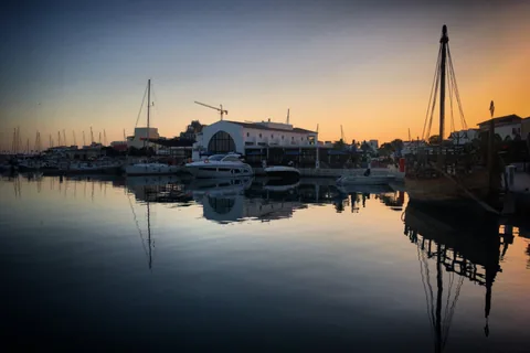 Hafen im Abendlicht mit Spiegelungen von Booten und Masten